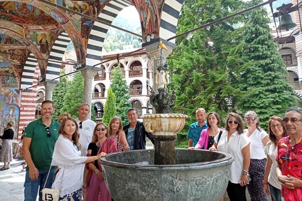 un gruppo di persone in piedi davanti a una fontana