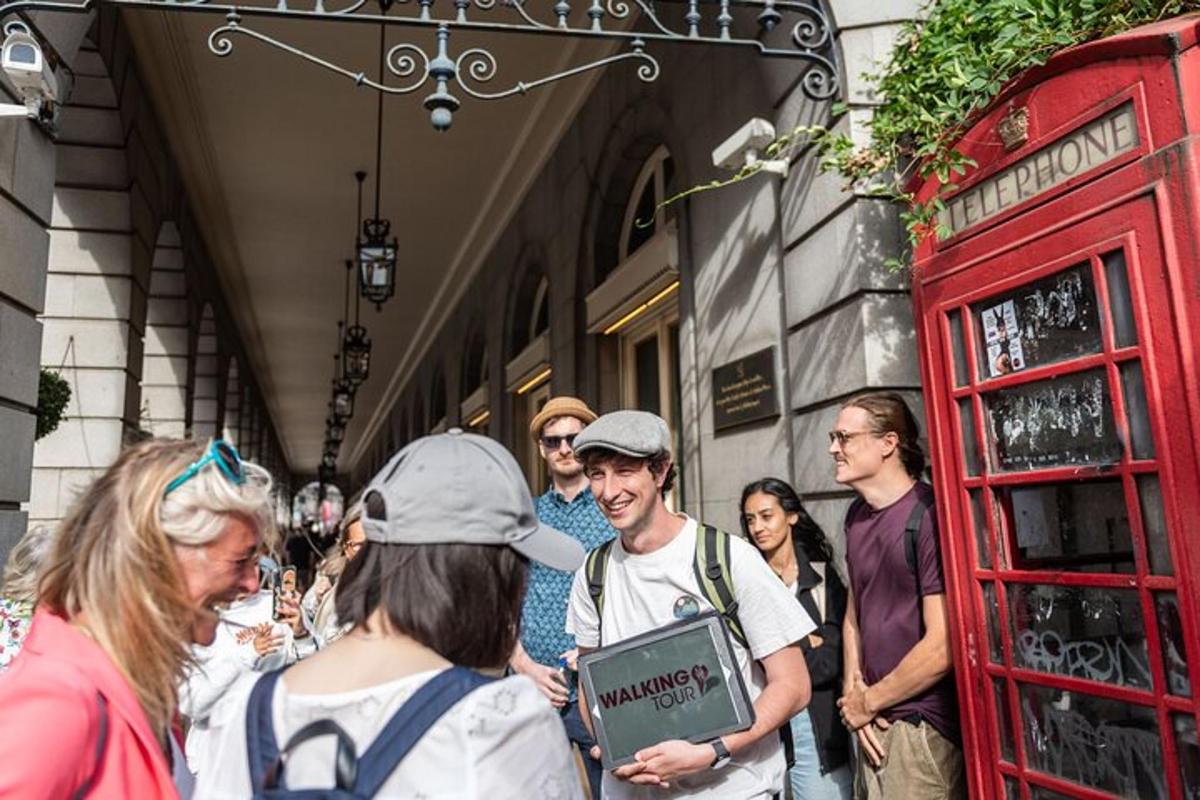 a group of people standing outside of a red phone booth