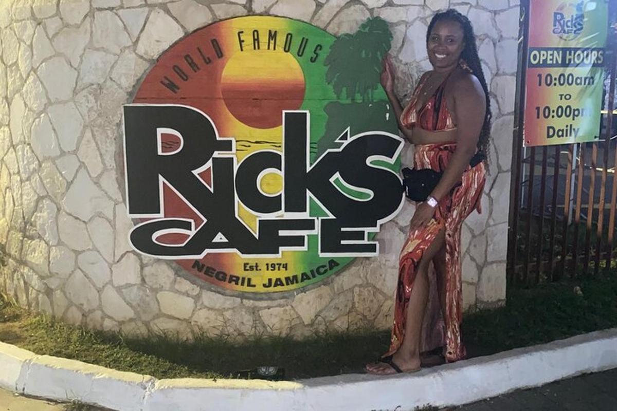 una donna è in piedi accanto a un muro di roccia