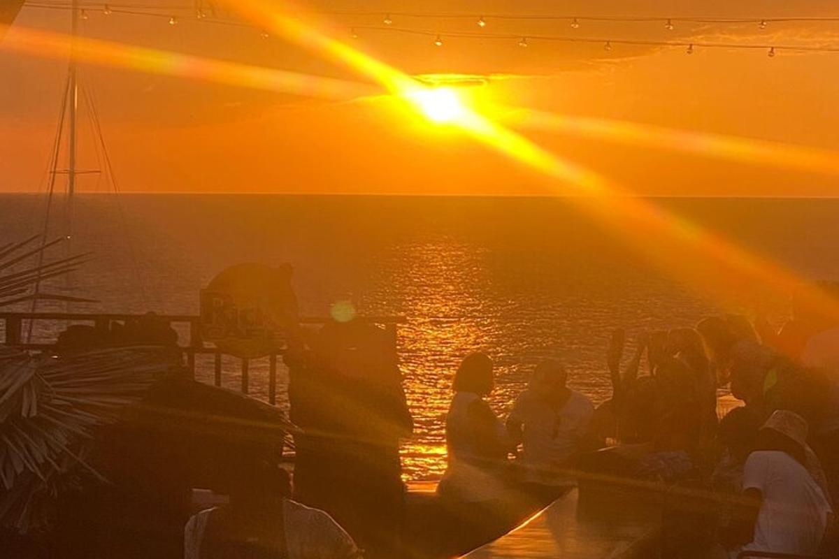 un gruppo di persone che guarda il tramonto su una barca