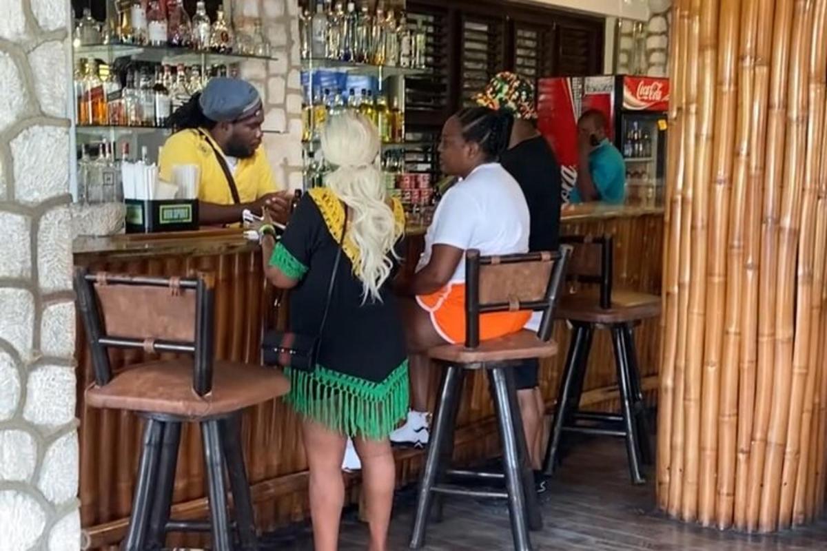 žena stojící u baru s barmanem