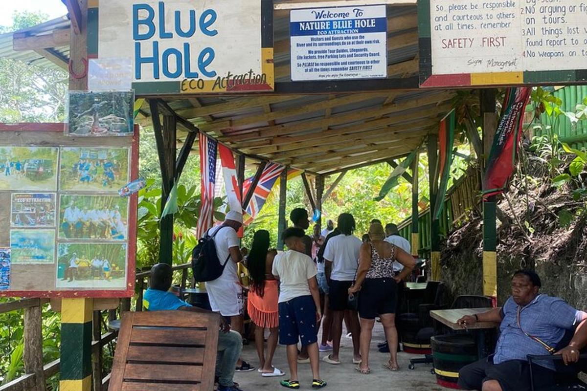 Un grupo de personas de pie bajo una choza azul.