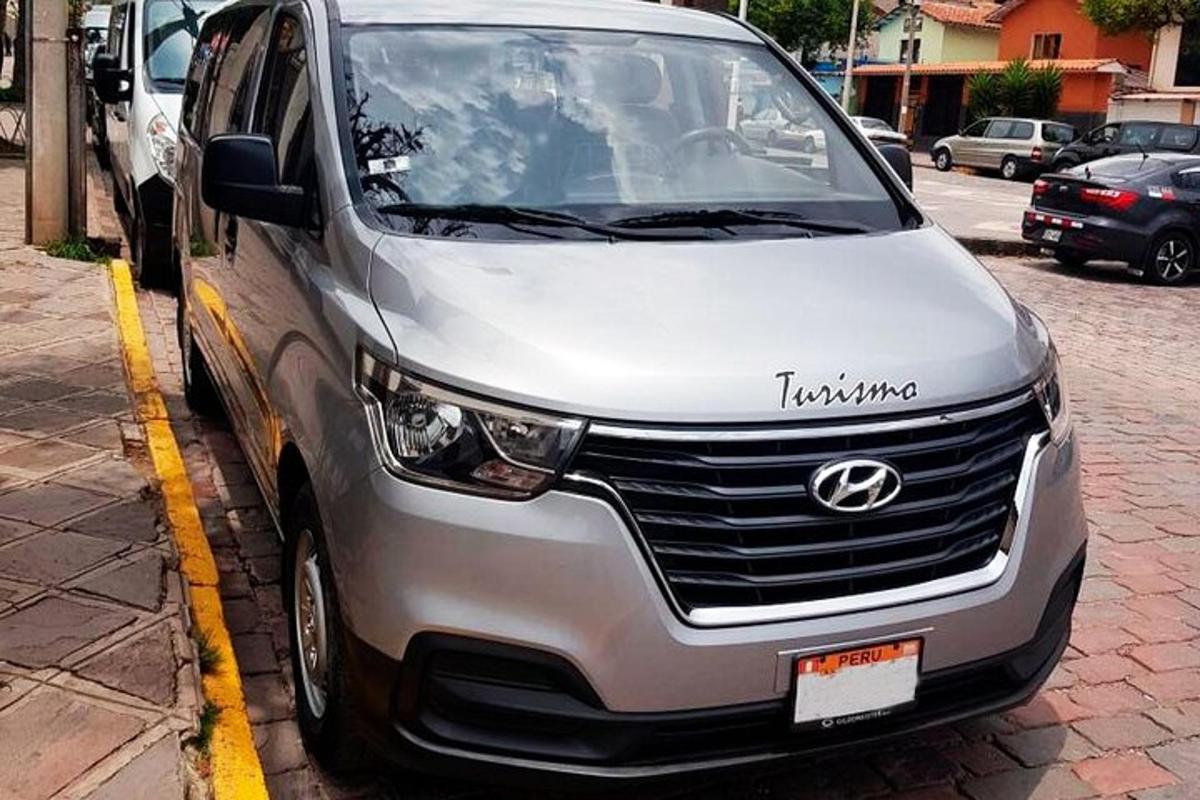 stříbrná dodávka zaparkovaná vedle parkovacího automatu