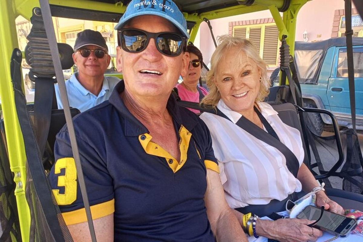 un home i una dona asseguts en un carret de golf