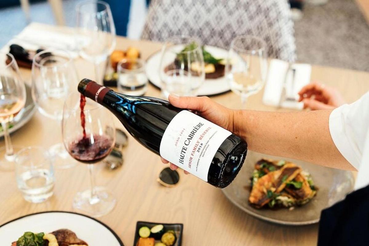 oseba, ki naliva kozarec vina na mizo