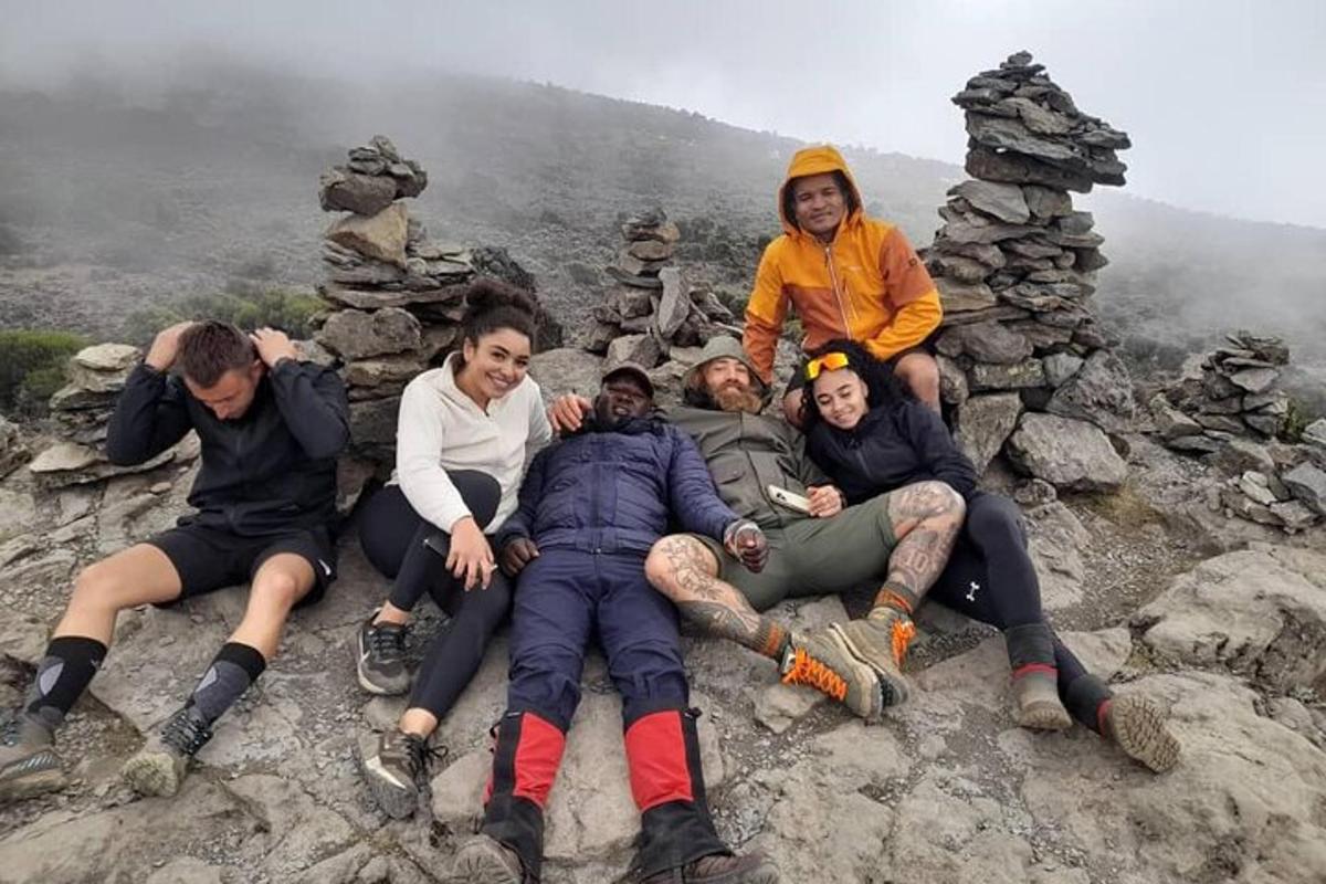 een groep mensen die op de top van een berg zitten