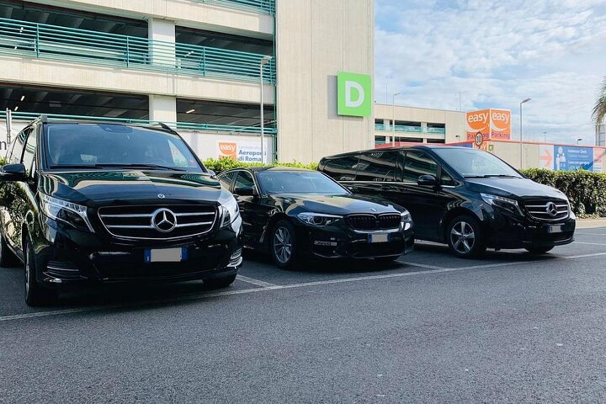 trys automobiliai pastatyti aikštelėje priešais pastatą