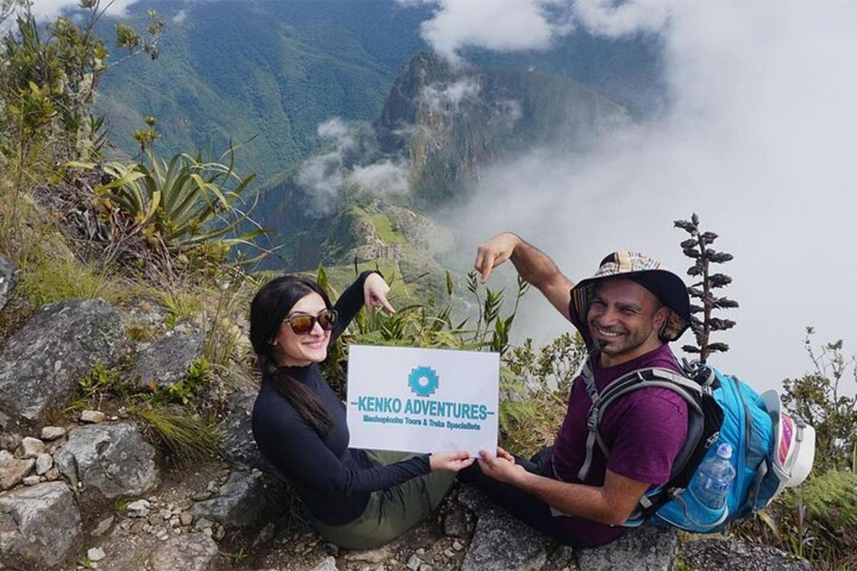 un uomo e una donna che tengono un cartello su una montagna