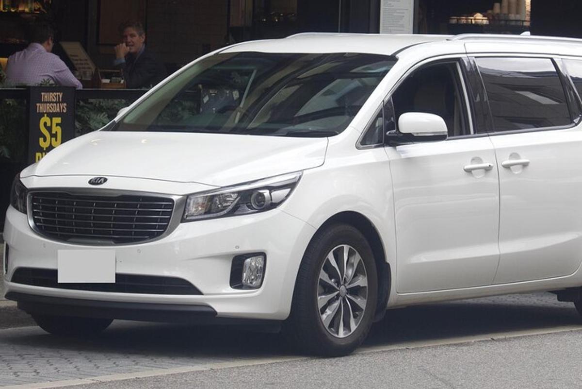 sebuah mobil van putih terparkir di jalan kota
