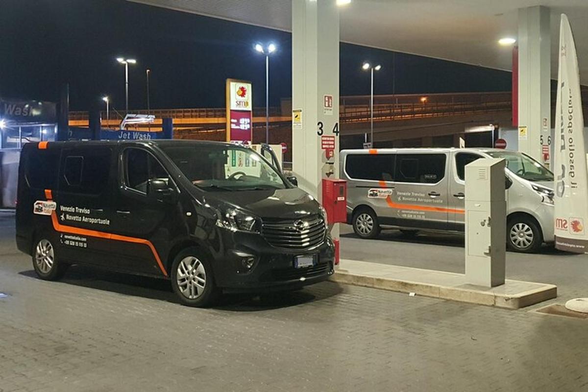 Černá dodávka zaparkovaná v noci u čerpací stanice