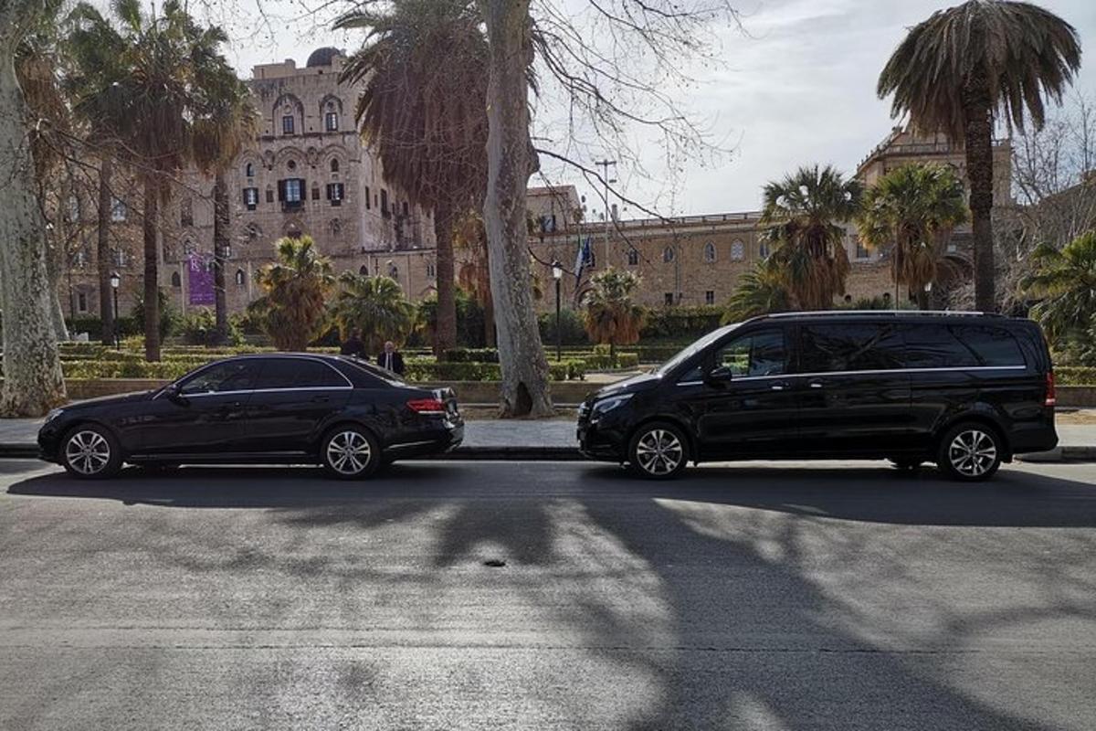 kaks autot pargitud hoone ees asuvale parklale