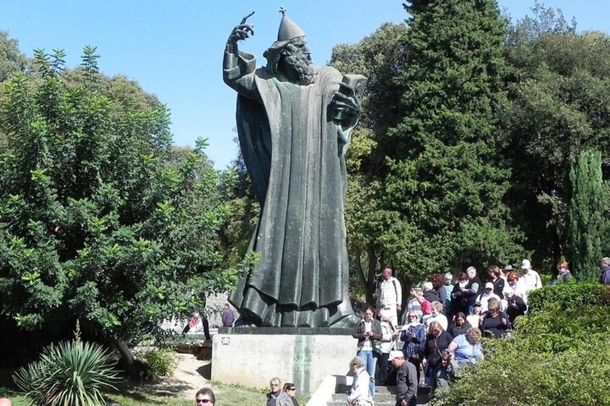 egy szobor körül álló embercsoport