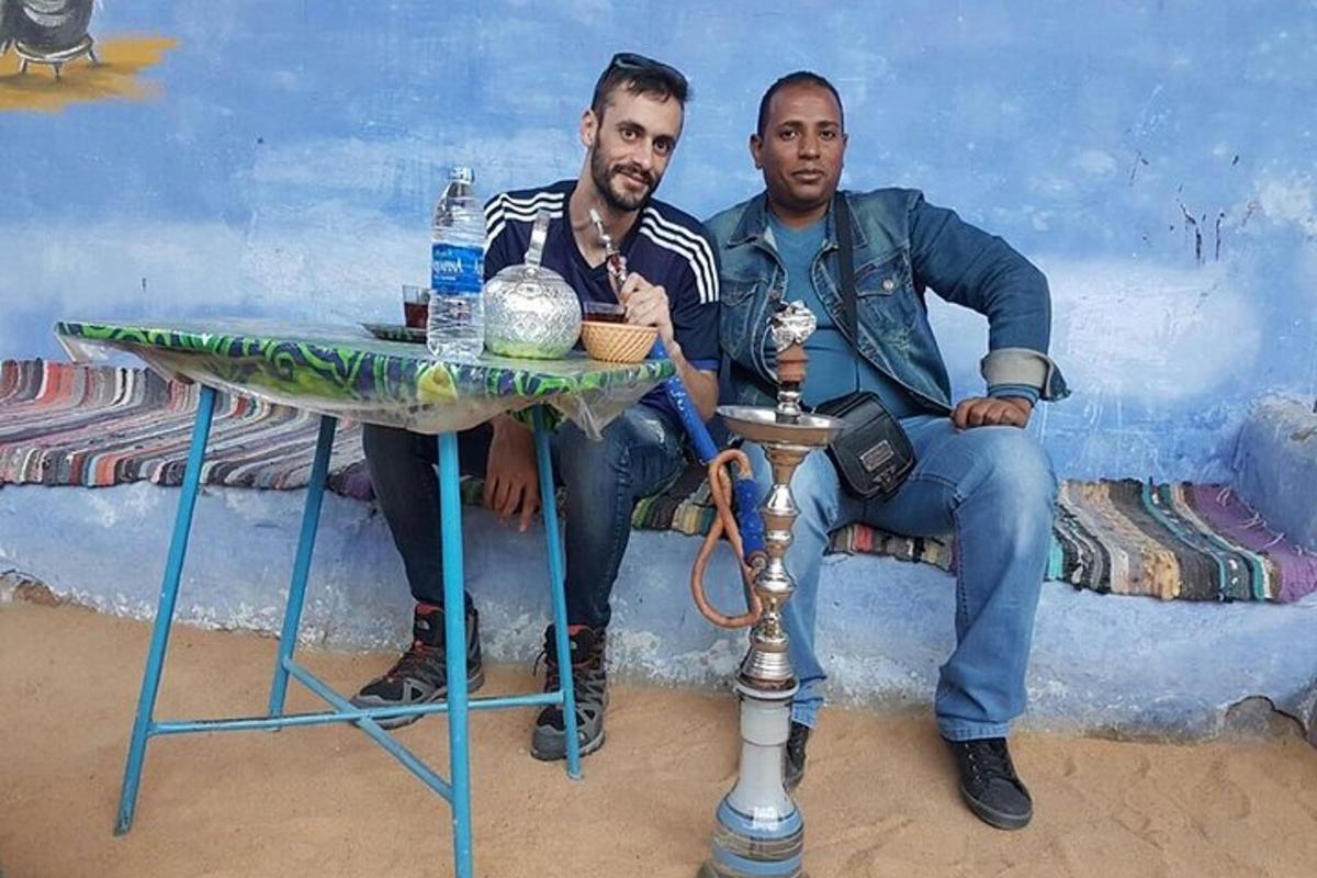 zwei Männer sitzen an einem Tisch vor einem Gemälde