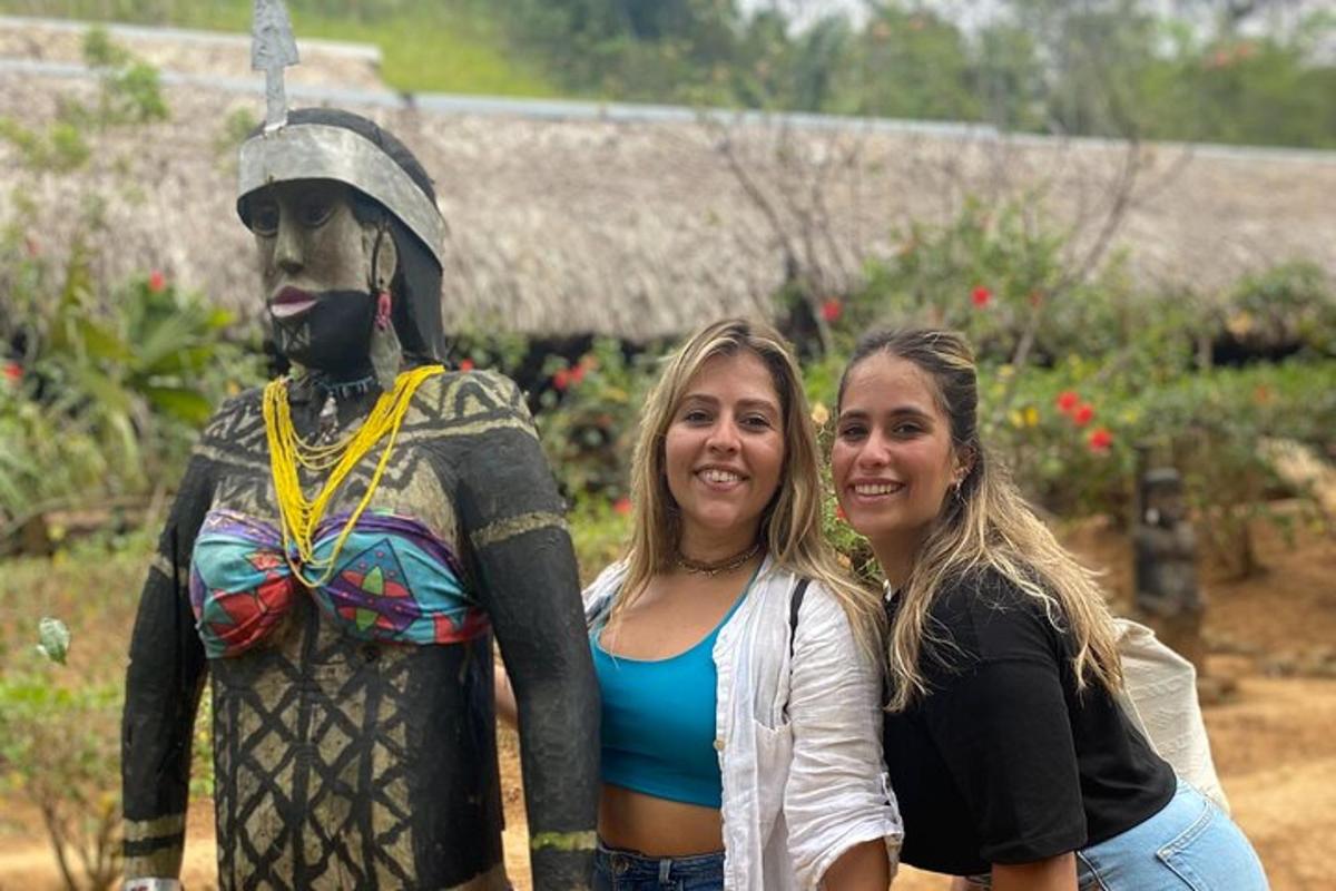 due donne in piedi accanto alla statua di un uomo