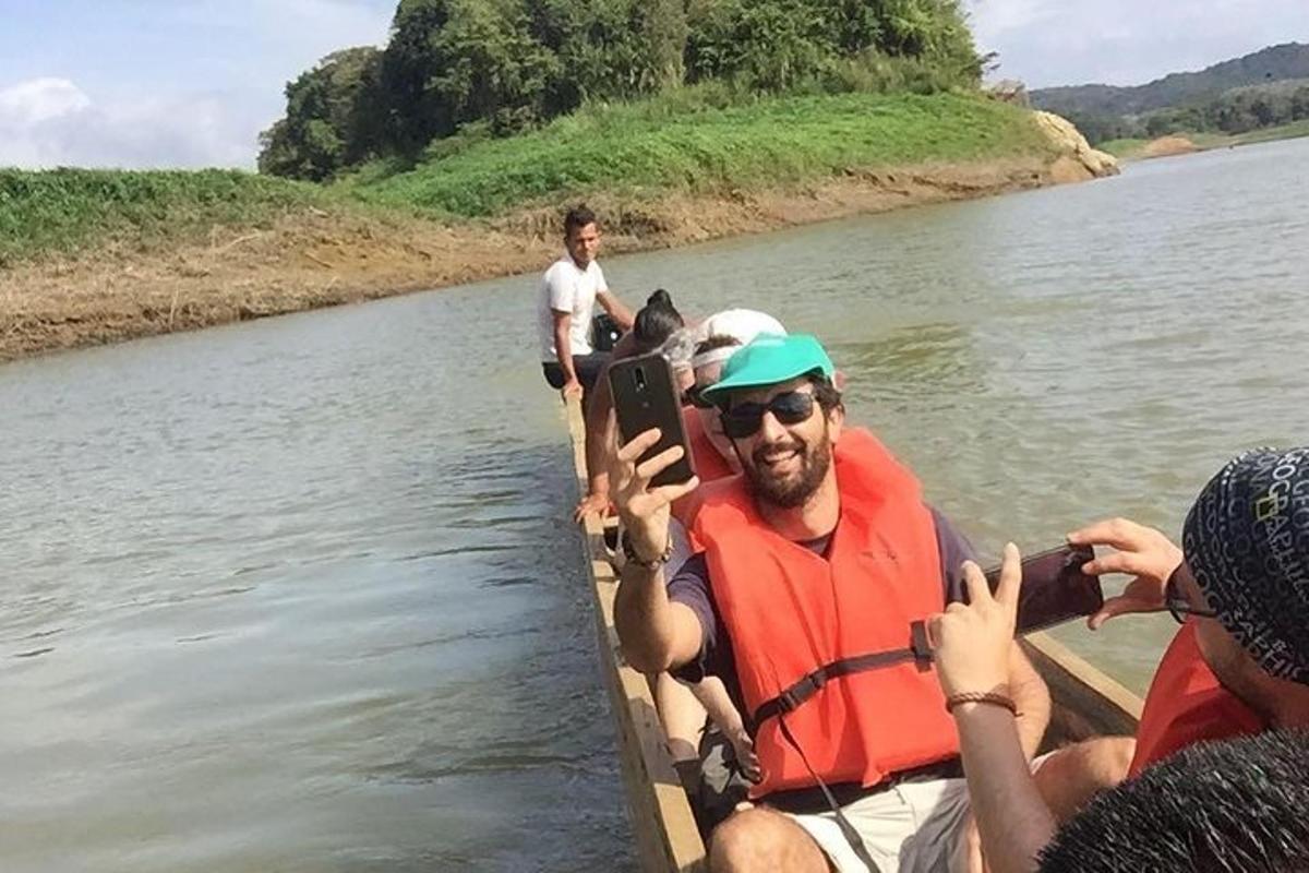 un uomo su una barca su un fiume con persone che scattano foto