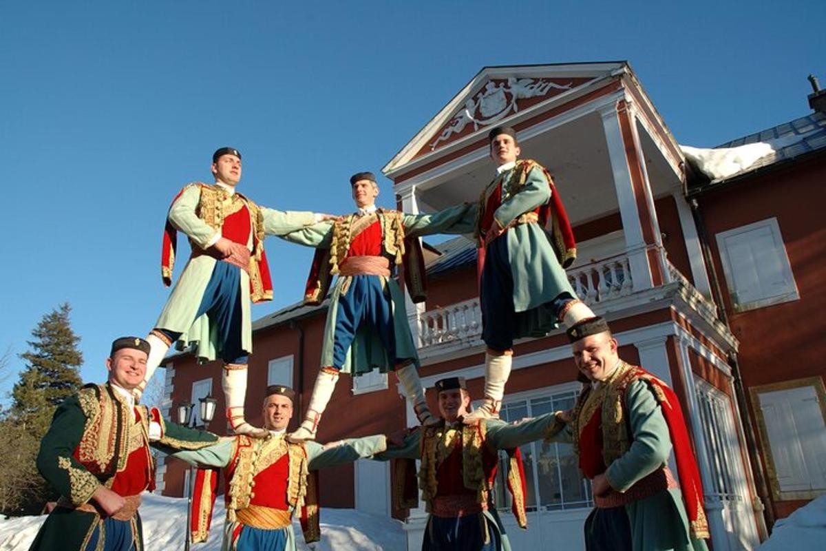 hópur karla í búningum standa fyrir framan hús