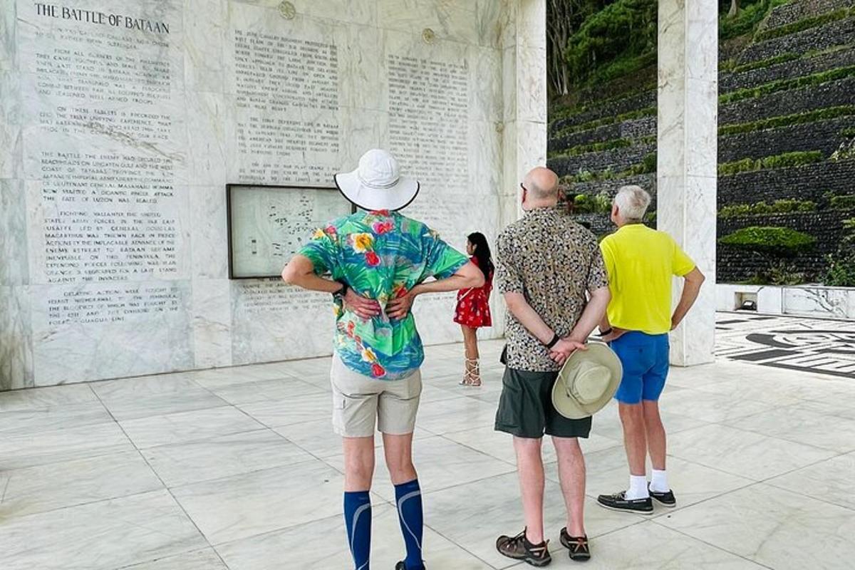 cilvēku grupa stāv pie kara memoriāla