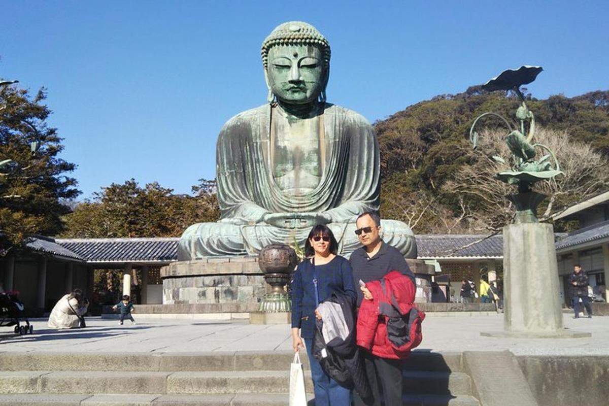 Un hombre y una mujer de pie frente a una estatua