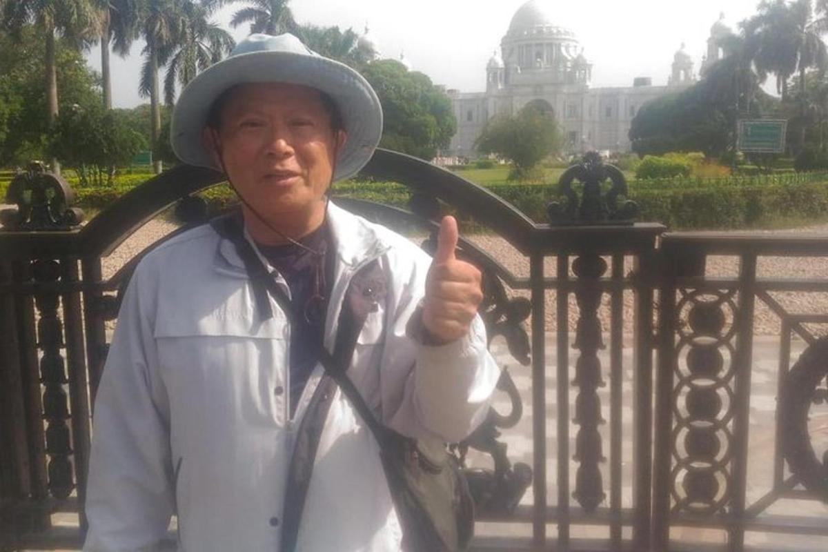 một người đàn ông đội mũ và giơ ngón tay cái lên