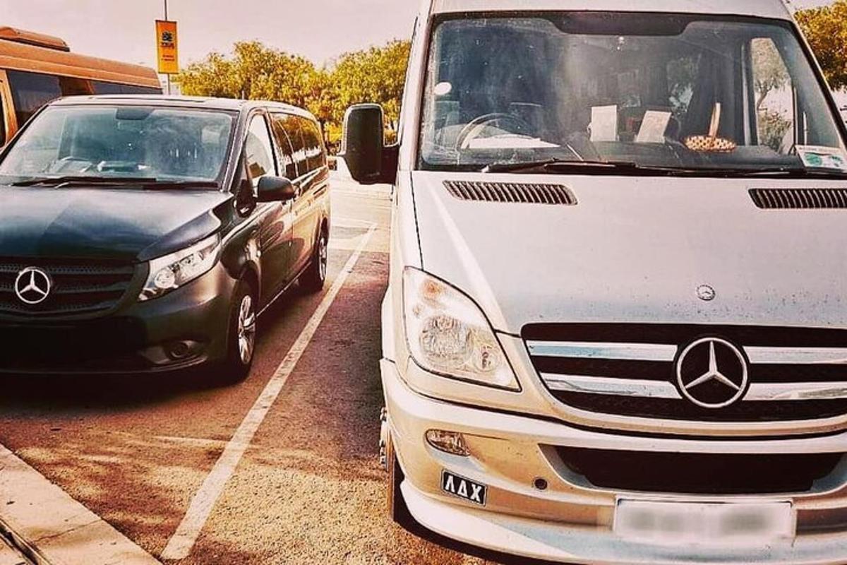 valge kaubik ja must auto pargitud parklas