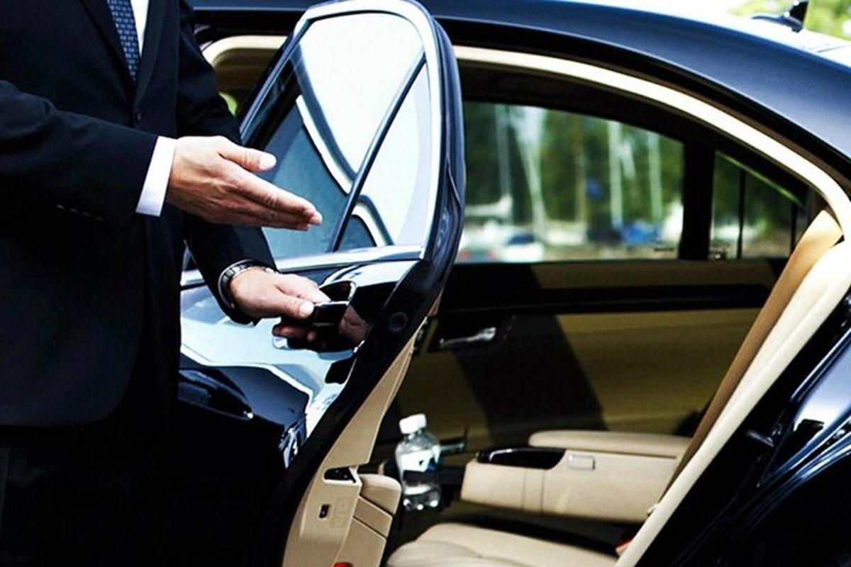 un uomo in giacca e cravatta che sale in macchina