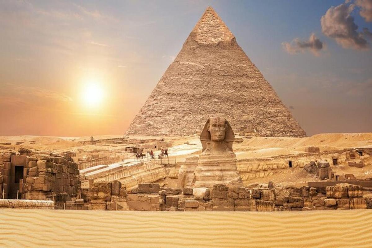 a pyramid and a statue in front of the pyramids