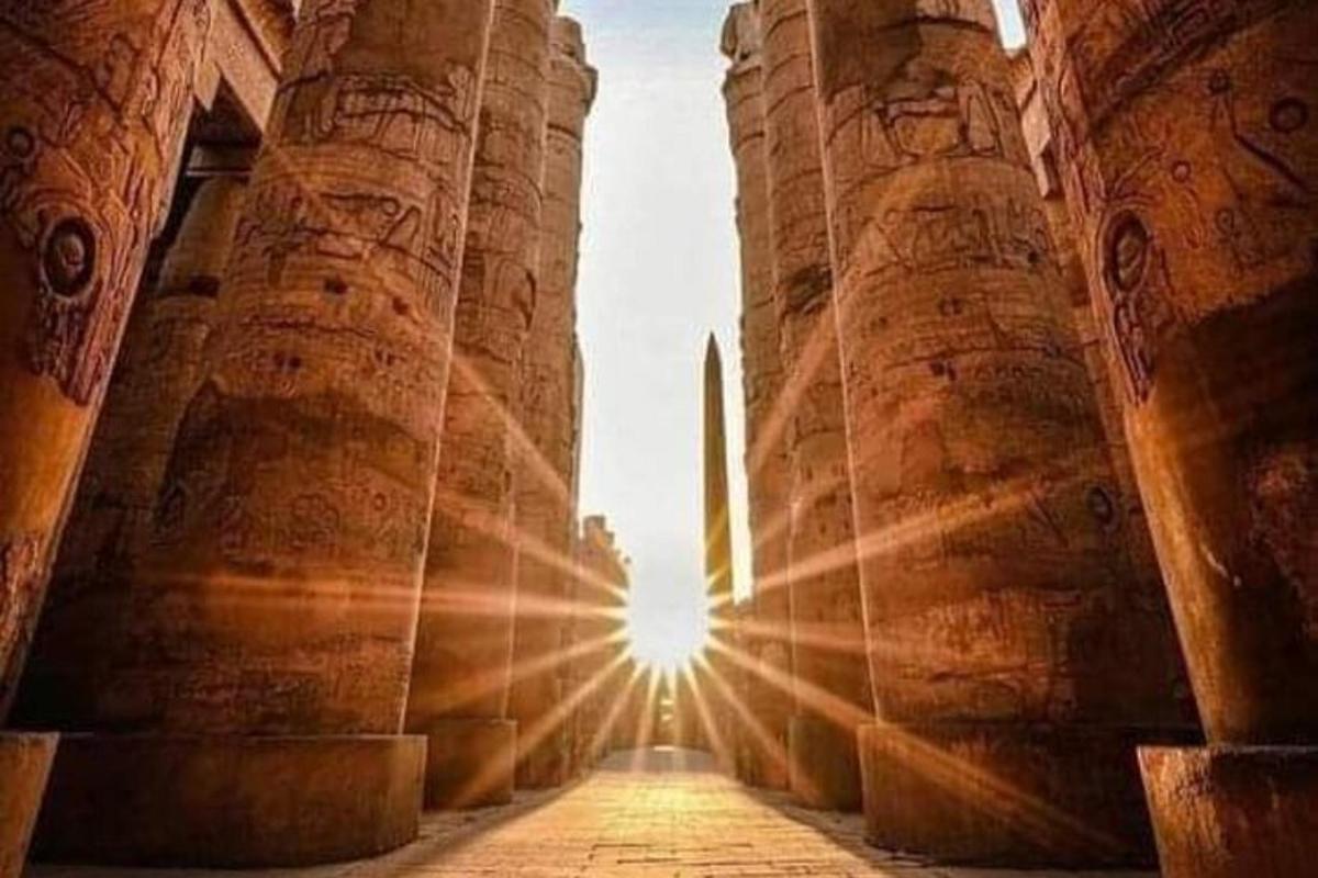 una vista del sol brillant a través de les ruïnes d'un temple