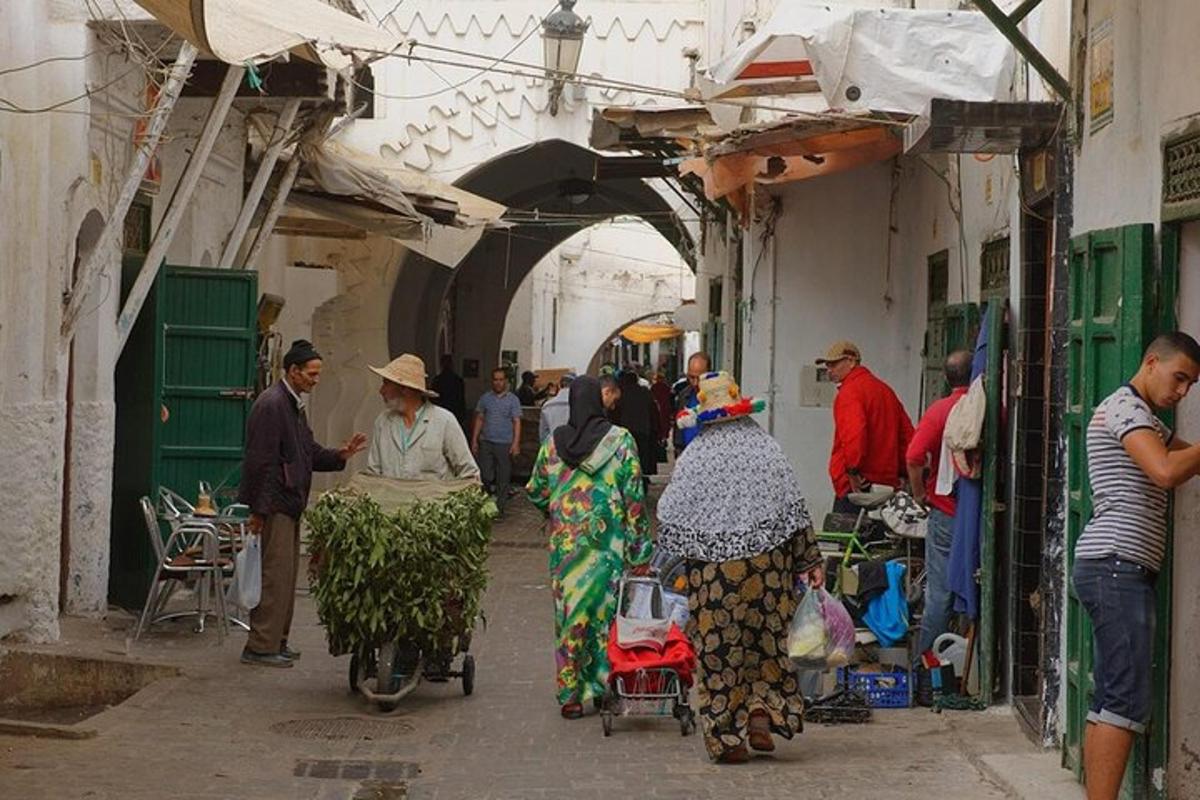 un grup de persones passejant per un mercat en un carreró