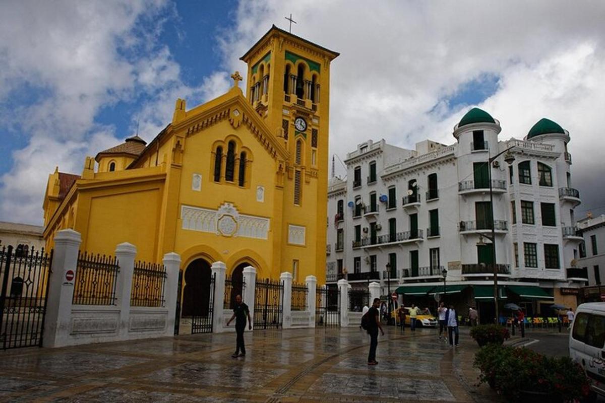 un edificio giallo con una torre dell'orologio in una città