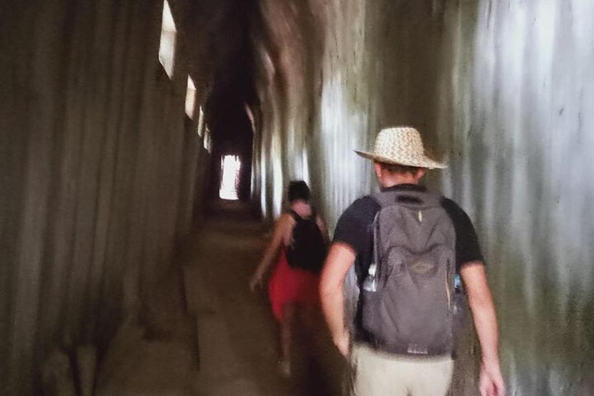 un home amb una motxilla caminant per un túnel