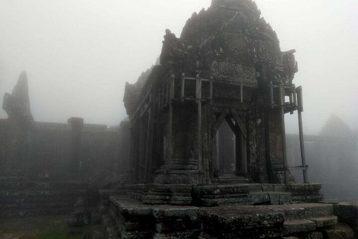 un edifici antic en un turó a la boira