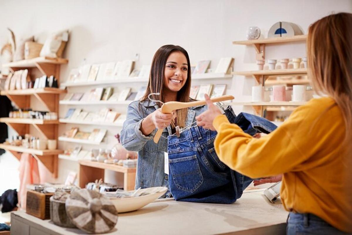 Dos mujeres paradas en un mostrador en una tienda sosteniendo