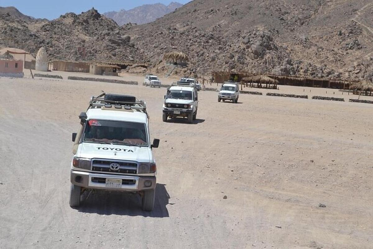 um grupo de caminhões dirigindo por uma estrada de terra
