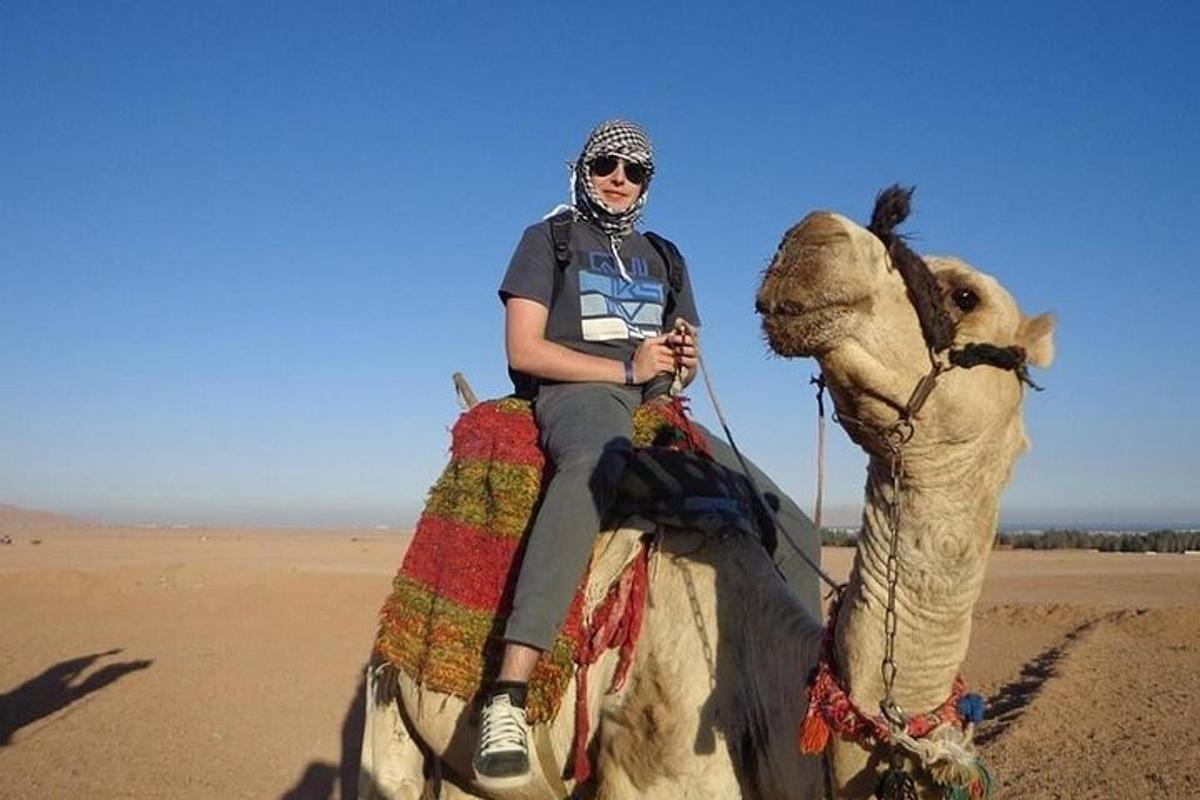 una mujer montando un camello en el desierto