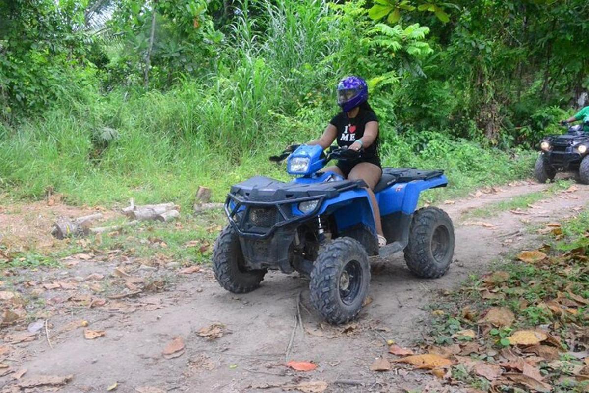 eine Person, die auf einem Quad auf einer unbefestigten Straße fährt