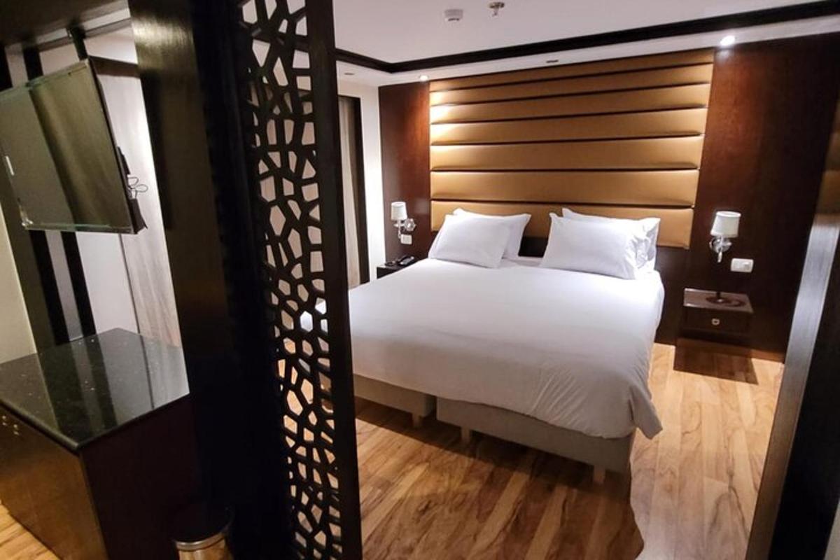 una camera da letto con un letto bianco con testiera in legno