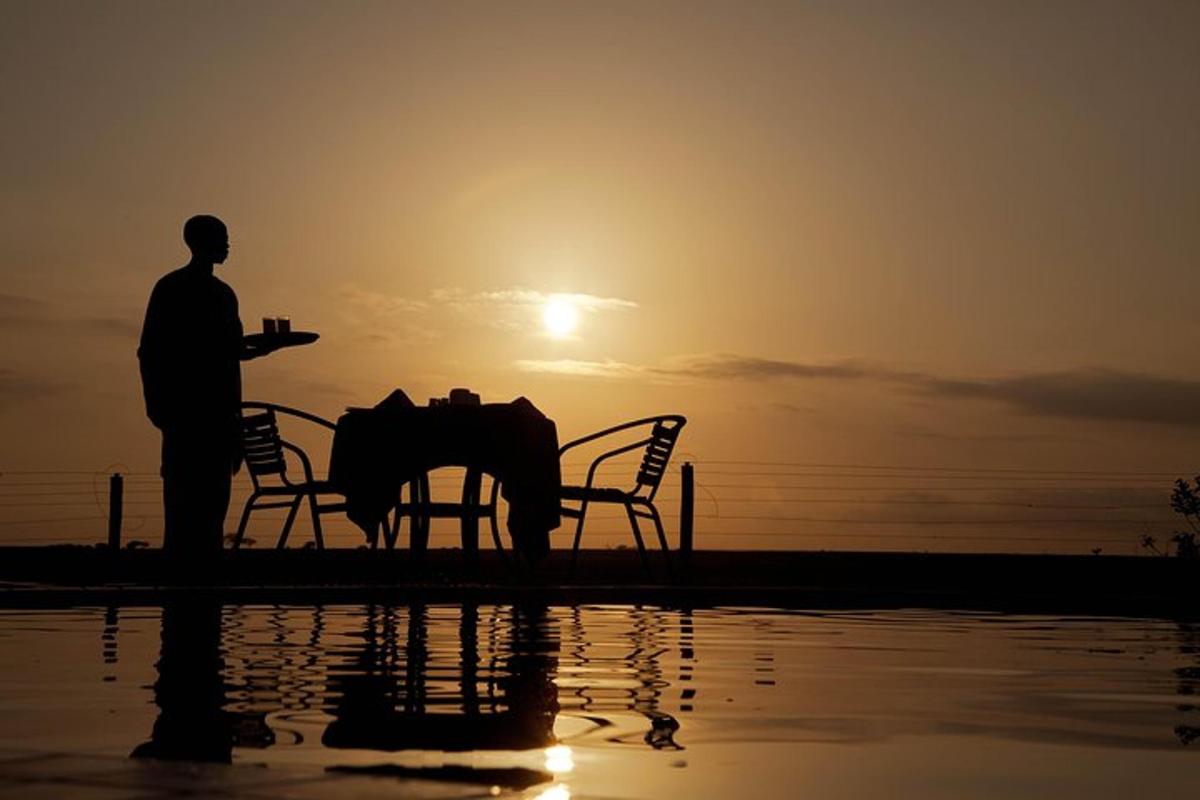 un uomo in piedi davanti a un tavolo con un tramonto