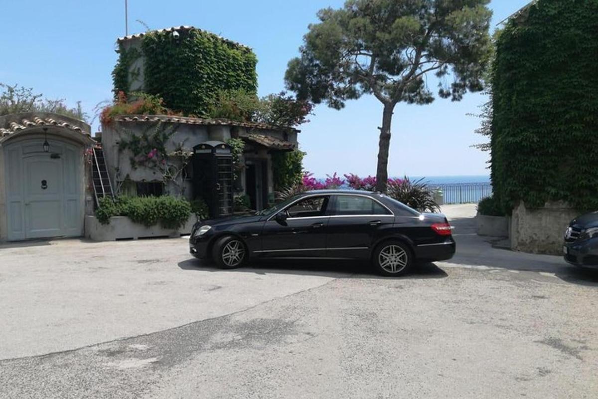 um carro preto estacionado em frente a uma casa
