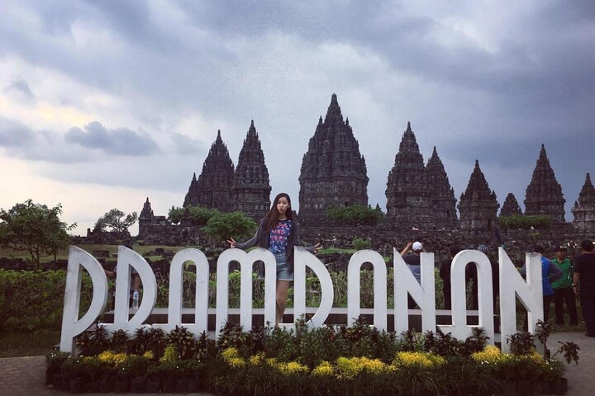 seorang wanita berdiri di hadapan papan tanda di hadapan kuil