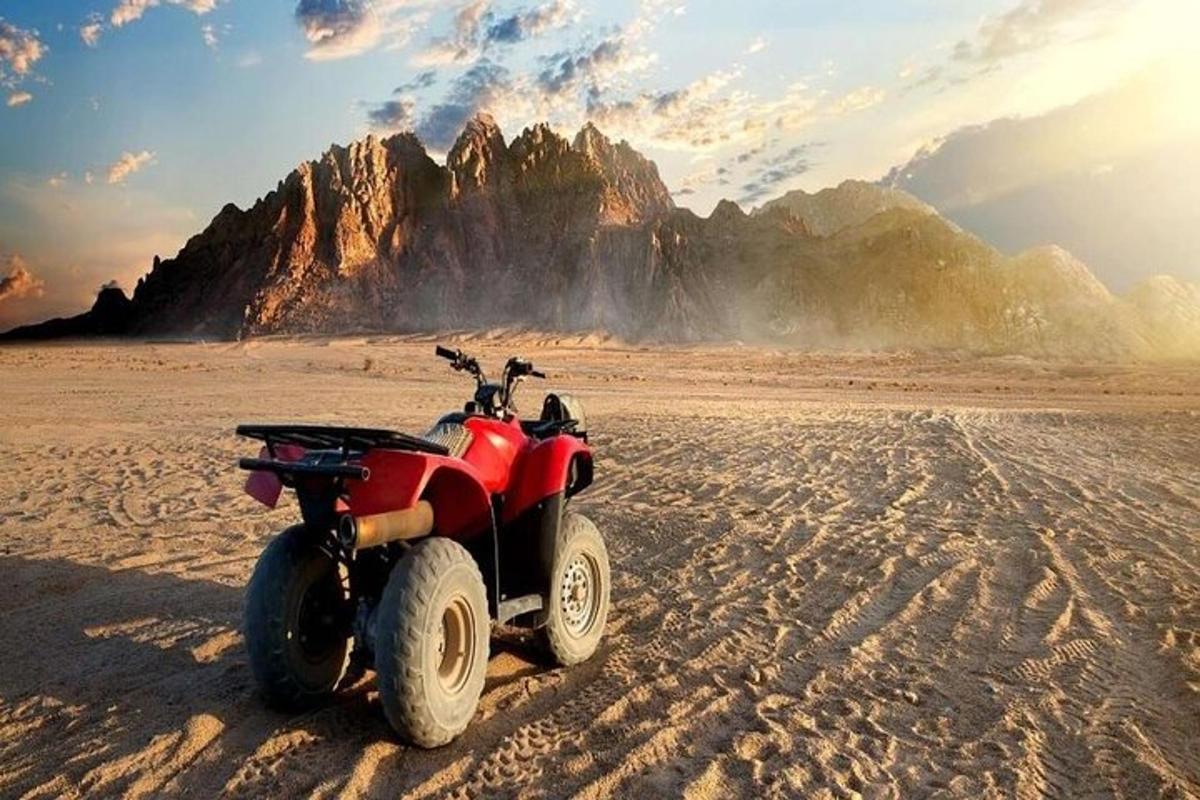 Egy piros ATV parkolt a sivatag homokjában