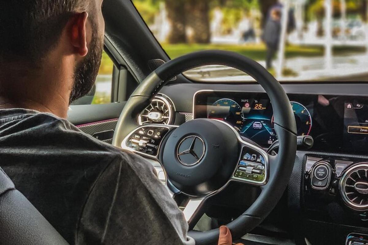 a man driving a car with a steering wheel
