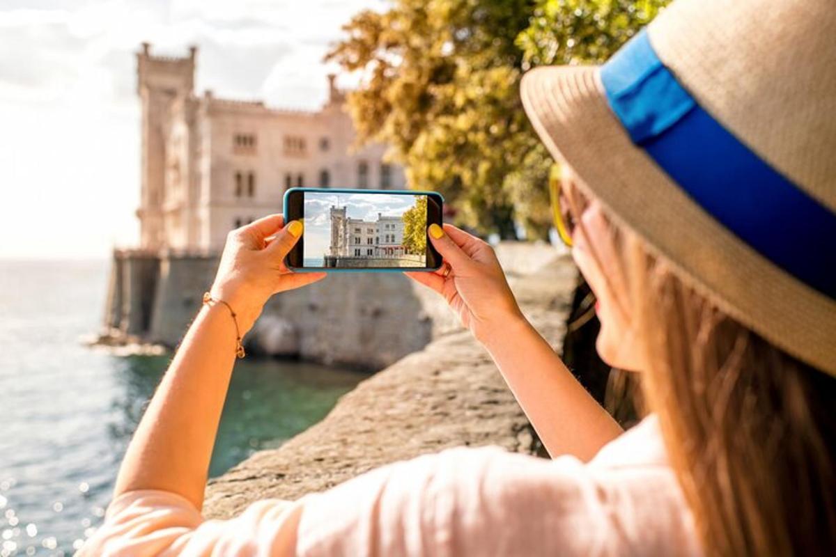 žena fotící budovu mobilním telefonem