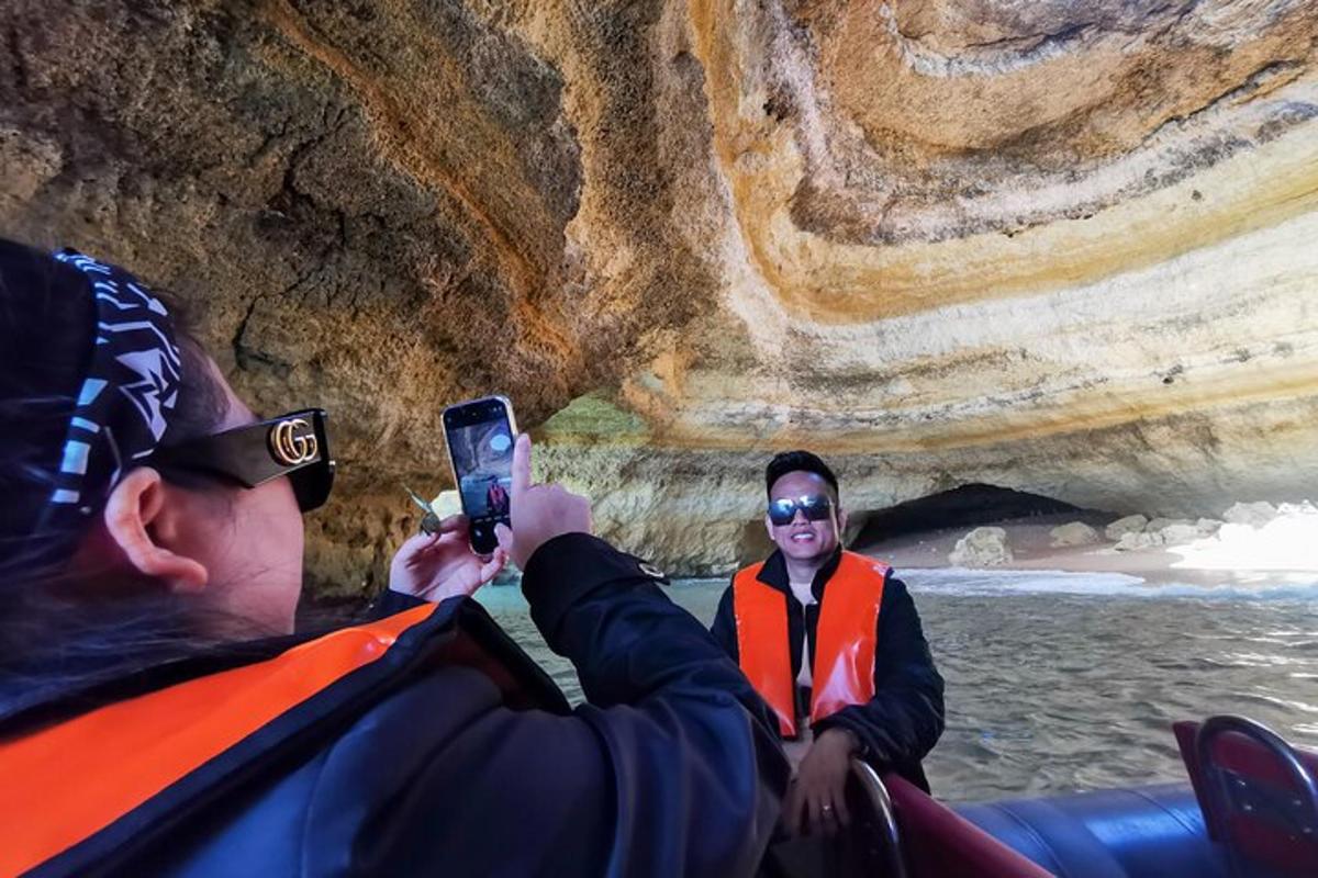 um homem tirando uma foto de duas pessoas em um barco