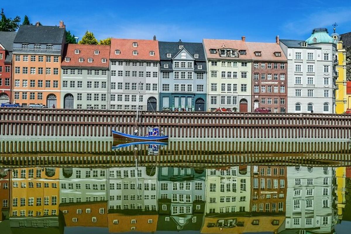 a reflection of a building in the water with a boat