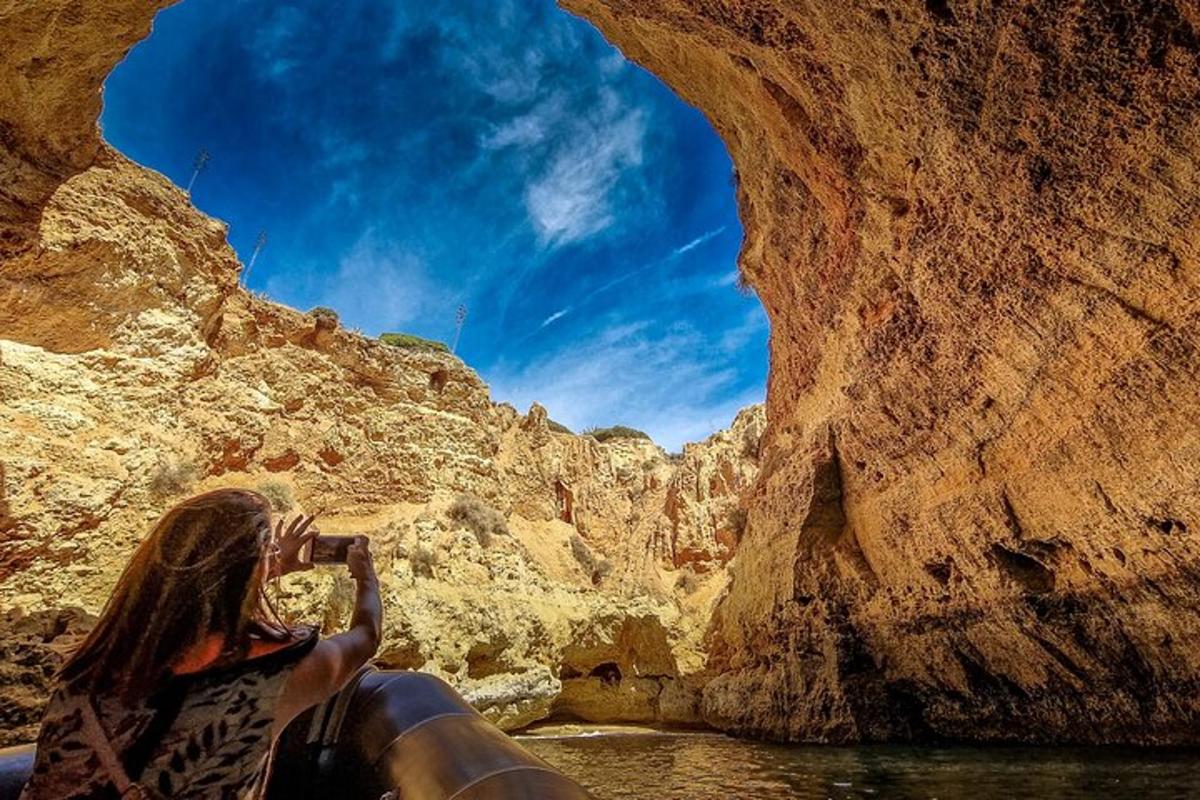 una donna che scatta una foto di un canyon con una macchina fotografica