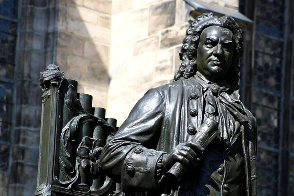 una estàtua de bronze d'un home que sosté un llibre