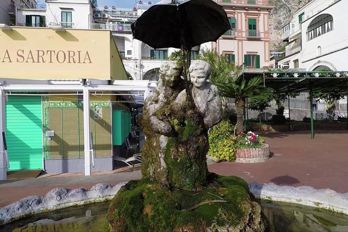 une statue d'une femme tenant un parapluie