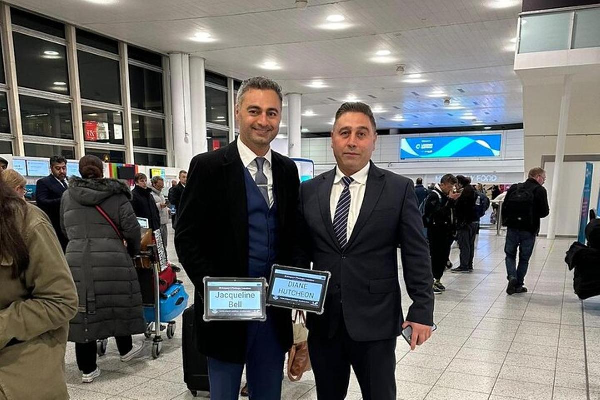 رجلان يرتديان بدلات ويحملان شهادات في المطار