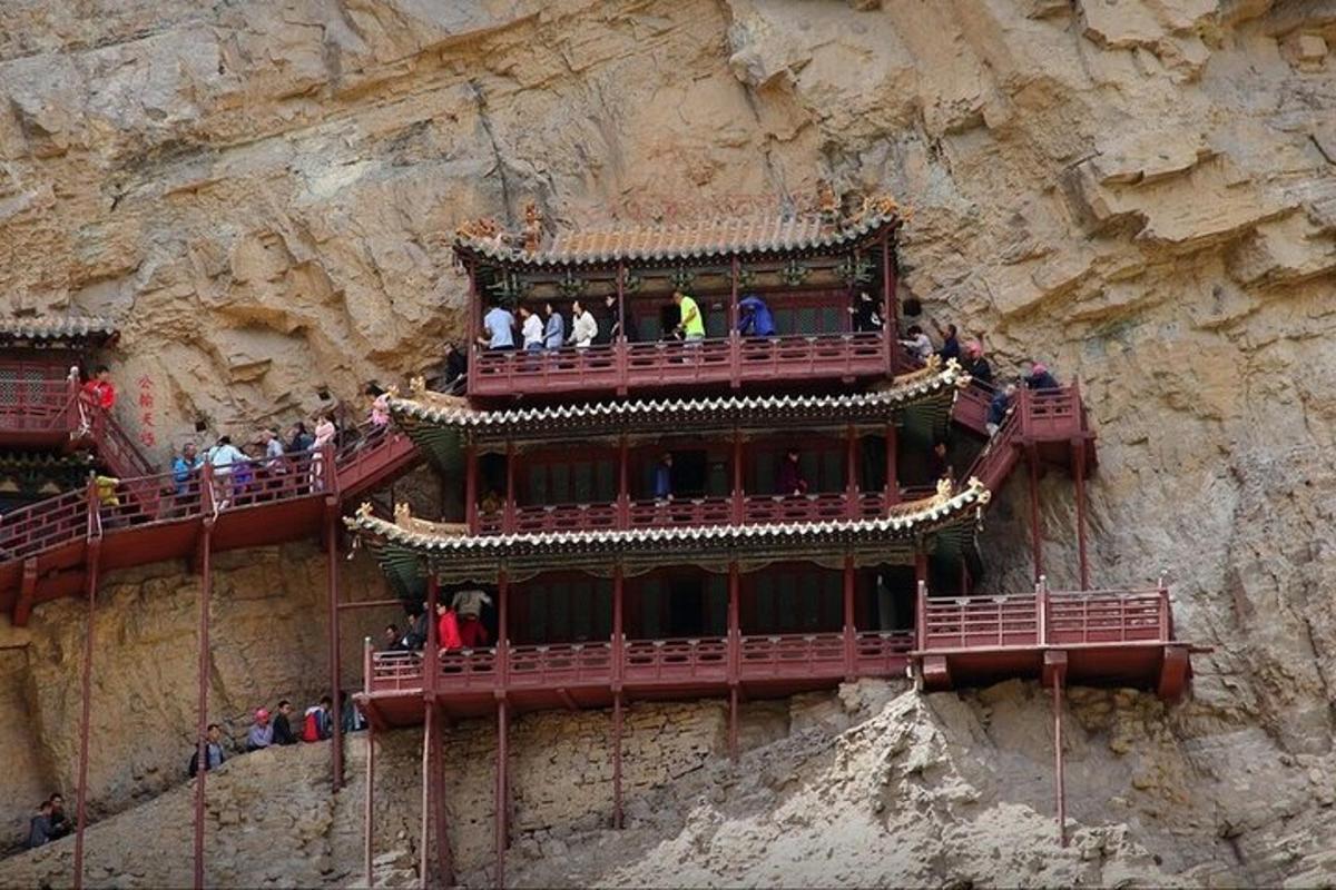 people are standing on a balcony on a mountain