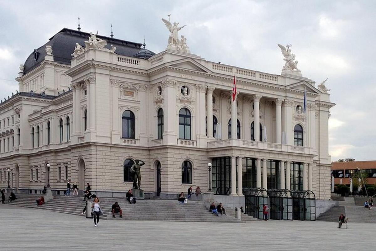 Un edificio blanco con gente caminando frente a él.